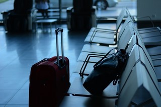 chairs at airport with abandoned luggage and purse